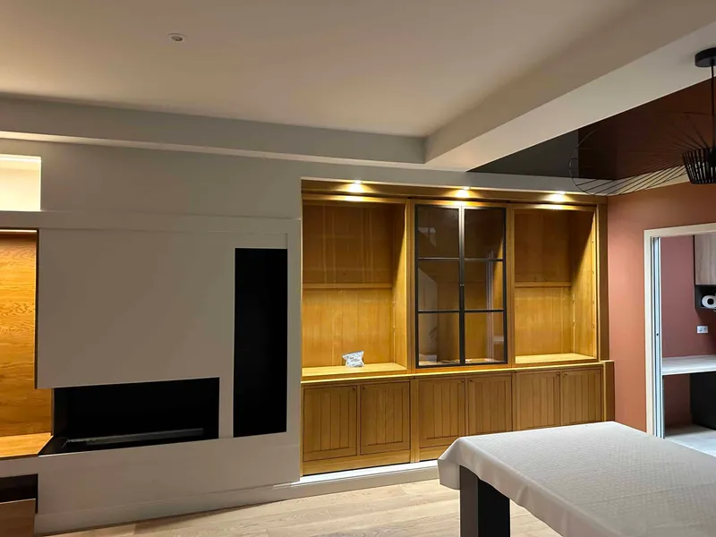 Salon contemporain avec bibliothèque en bois verni et éclairages intégrés