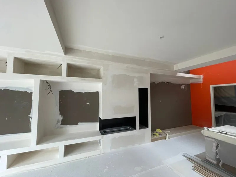 Structure en plaques de plâtre en cours de réalisation autour d’une cheminée horizontale