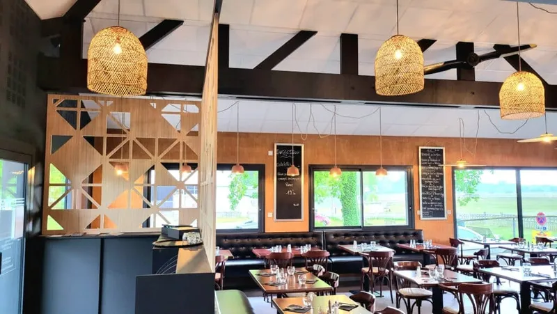 Intérieur de restaurant contemporain avec banquettes, claustra en bois et suspensions en fibres naturelles